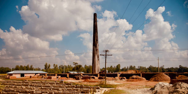 campo dos tijolos com chaminé alta em torno de uma área urbana - house farm brick chimney - fotografias e filmes do acervo