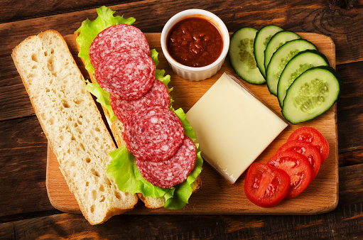 Ingredients for a tasty and delicious sandwich with salami and vegetables