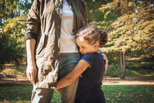 niña triste abrazando a la madre en el parque. - shy fotografías e imágenes de stock