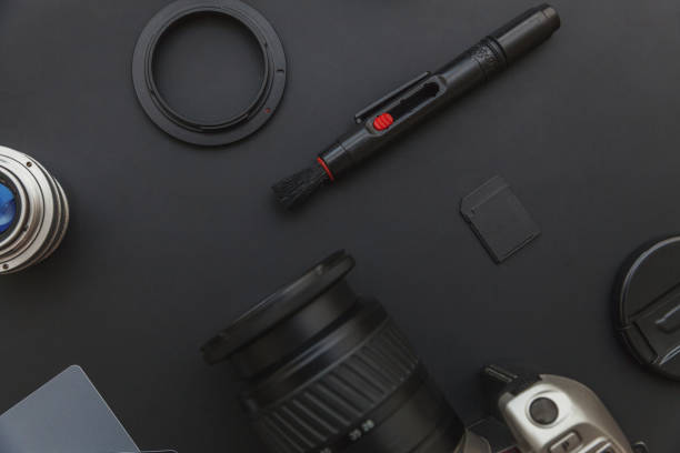 istock Photographer workplace with dslr camera system, camera cleaning kit, lens and camera accessory on dark black table background. Hobby travel photography concept Flat lay top view copy space 1188219174