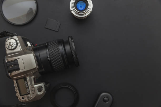 istock Photographer workplace with dslr camera system, camera cleaning kit, lens and camera accessory on dark black table background 1188219184