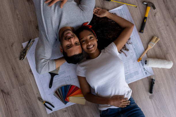 istock Couple remodeling their house and lying down on a blueprint 1188220313