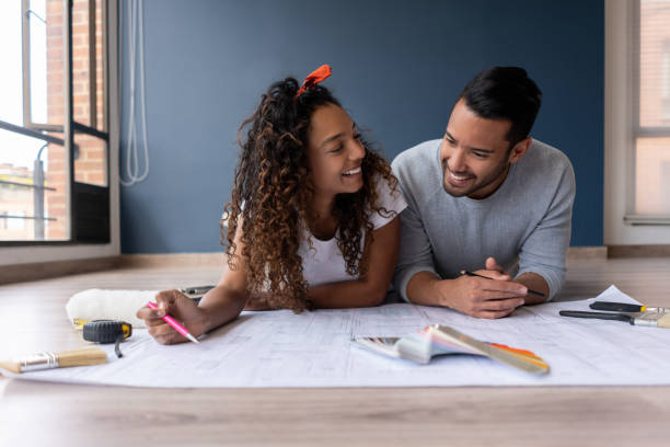 istock Couple remodeling their house and looking at a blueprint 1188220354