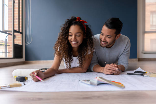 istock Couple remodeling their house and drawing a blueprint 1188220356