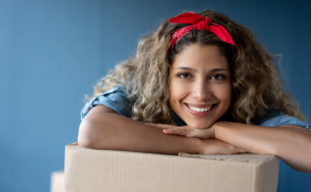 istock Happy woman moving house and packing in boxes 1188220392
