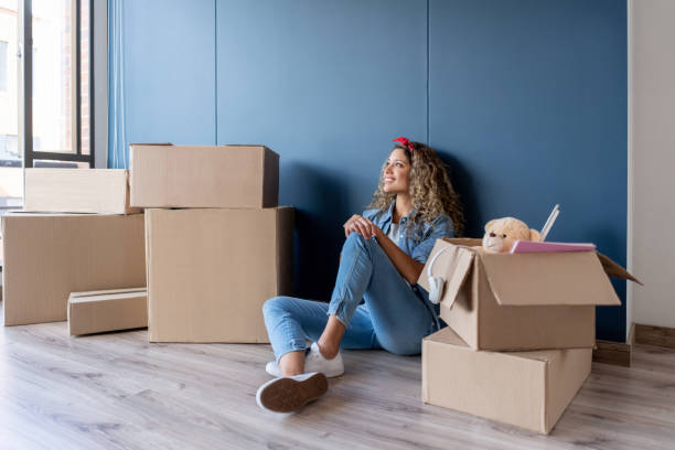 istock Woman moving house and daydreaming while packing 1188220400