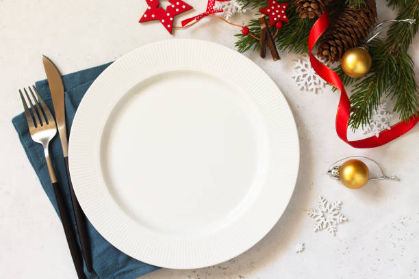 istock New Year, Christmas dinner, table setting. Christmas table with plate, silver and Fir branch on a white concrete table. Top view flat lay background. Copy space. 1188220593