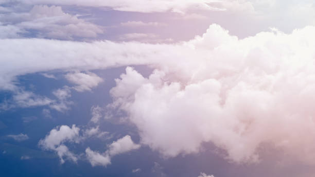istock White soft fluffy clouds over the green landscape, aerial view from the plane. 1188220702