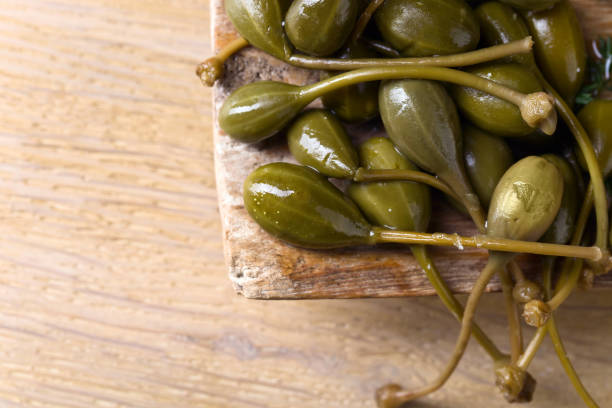 istock Canned capers in wooden dish . 1188220895