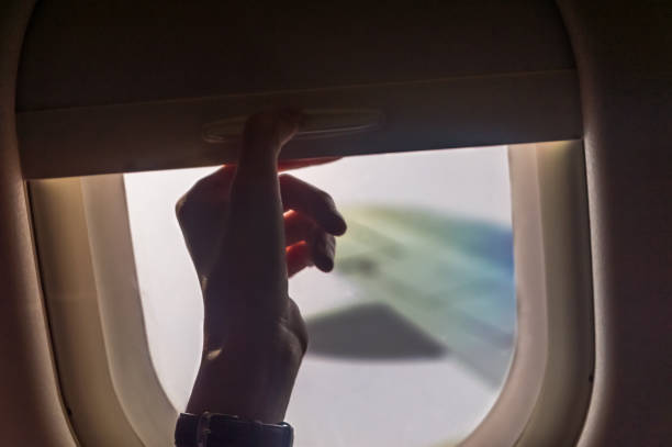 istock Woman hand closed plane window to keep bright light from coming in. 1188223112