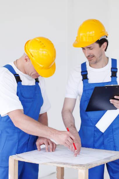 istock Builders in hardhats with blueprint 1188226099