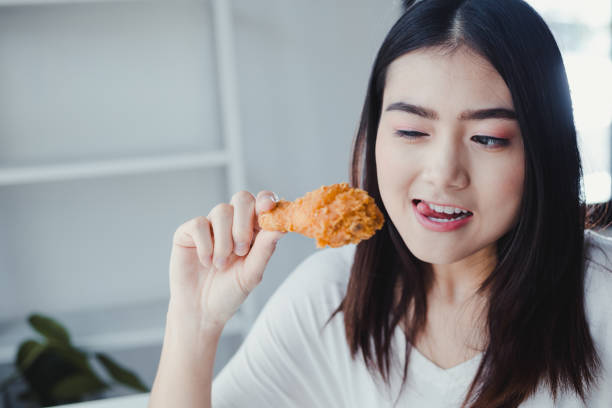 istock Girl holding fried chicken drumstick. 1188226197