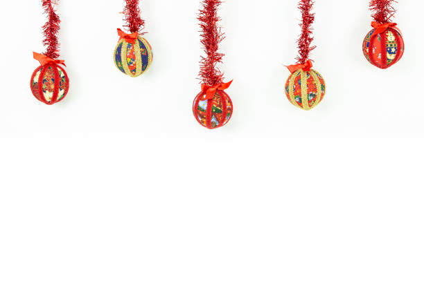 istock Christmas copy space: five Christmas baubles made by hand with the decoupage technique hung from top with a red shiny garland on white background 1188228920