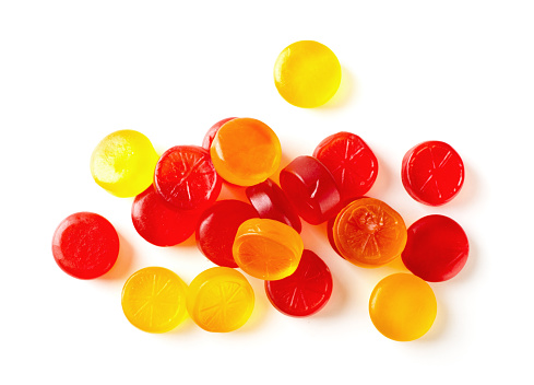 Colorful fruit hard candy isolated on white background top view