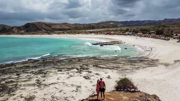 ломбок - пара, стоящая на краю обрыва - hiking coastline waters edge sunny стоковые фото и изображения