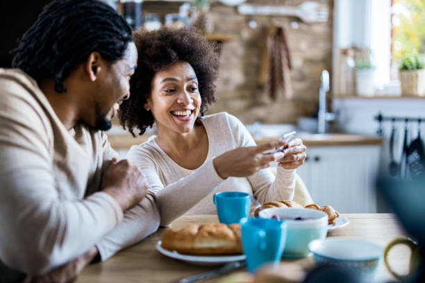 istock Happy black couple using cell phone during morning time at home. 1188231640