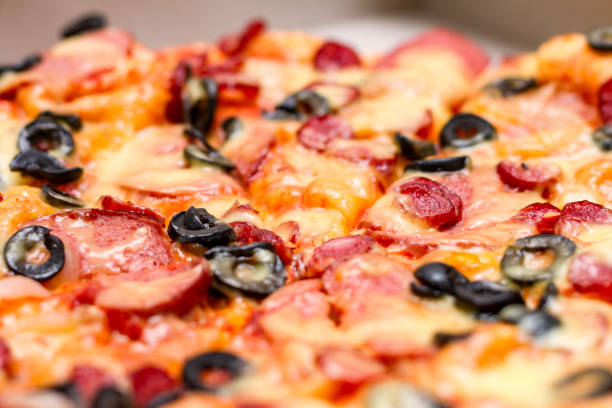 istock Pizza with salami, cheese and black olives, selective focus, close up 1188233349