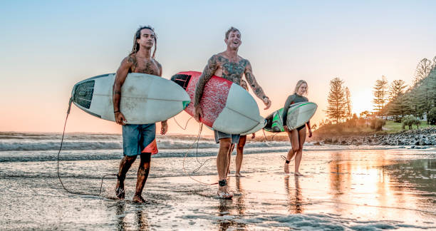 istock Friends walking along the coast with surfboards 1188236238