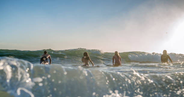 istock Friends running into the ocean with their surfboards at morning 1188236241
