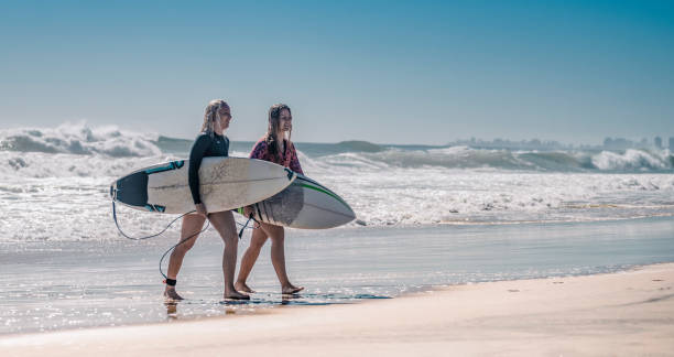 istock Friends walking along the coast with surfboards 1188236244