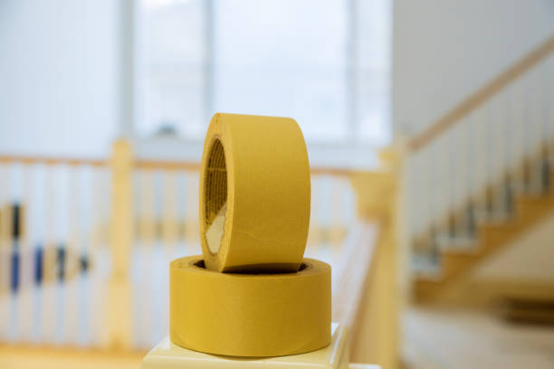 roll of yellow painters tape on masking tape from painting wall - paint preparation adhesive tape indoors imagens e fotografias de stock