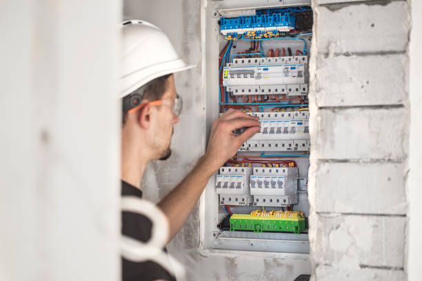 istock Man, an electrical technician working in a switchboard with fuses. Installation and connection of electrical equipment. 1188238266