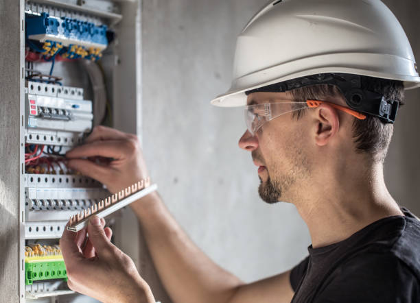 istock Man, an electrical technician working in a switchboard with fuses. Installation and connection of electrical equipment. 1188238278