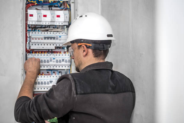 istock Man, an electrical technician working in a switchboard with fuses. Installation and connection of electrical equipment. 1188238289