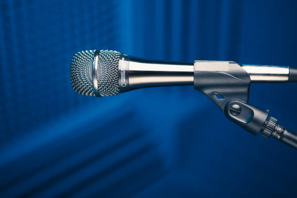 istock microphone on stand, blue background with acoustic foam wall in studio 1188239653