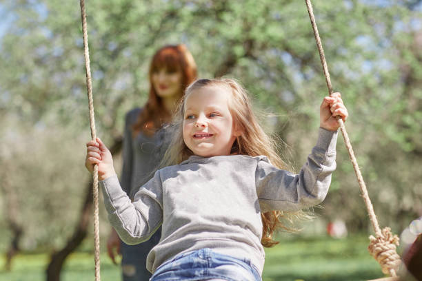 istock mom with her little daughter on the swing 1188241249