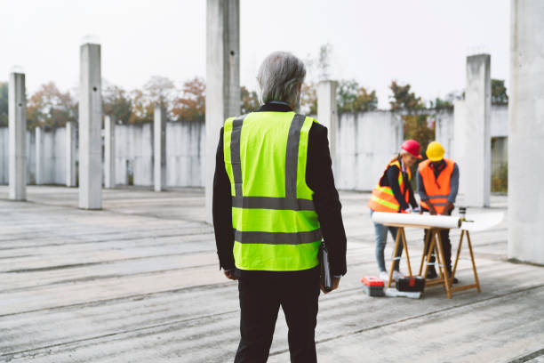 istock Architect in reflective vest supervising the work of his team on the construction site 1188241925