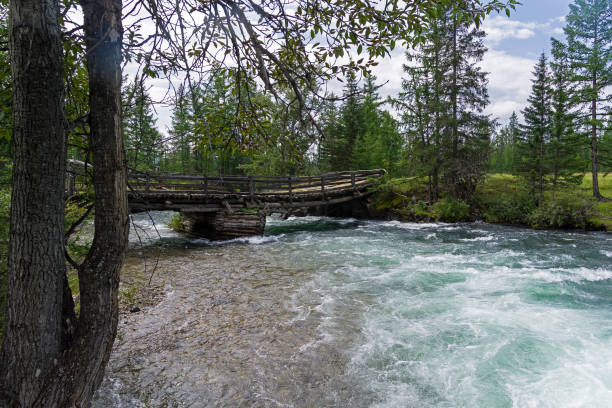 istock Old wooden bridge over the fast river. 1188243838
