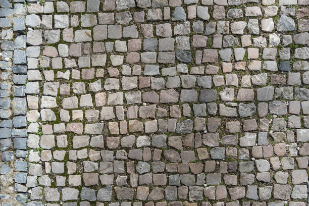 istock European granite cobblestone pavement with different stones. Gray stone background, textured pedestrian pavement, road in Europe. 1188244939