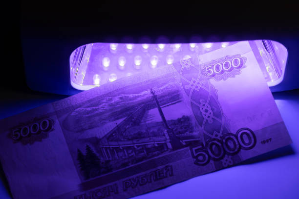 Five thousand Russian rubles in infrared light. Check on the detector. Check for fake or genuine. Counterfeiting banknotes, checking at the bank with a cashier of 5,000 rubles, by a banking operator. Financial, banking concept.
