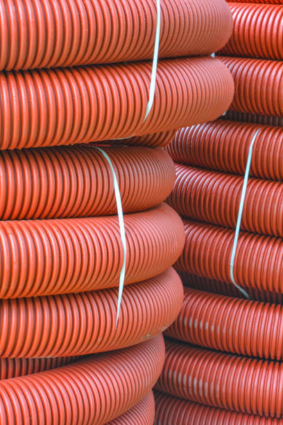 istock Coils of new red plastic pipe for underground cable protection with rain drops 1188246042