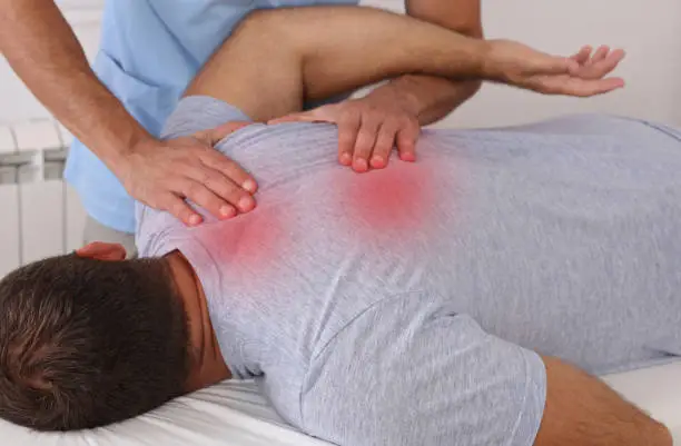 Photo of Chiropractic treatment. Shiatsu massage, Back Pain trigger points. Physiotherapy for male patient, Sport Injury Recovery