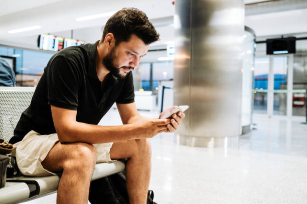 istock Happy passenger using phone at airport 1188254305