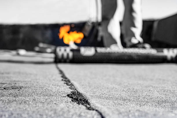 repair of bitumen roof with roll surfacing material with fire gas burner close-up, front and background blurred with bokeh effect - bitumen felt imagens e fotografias de stock