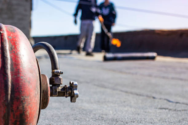 repair of bitumen roof with roll surfacing material with fire gas burner close-up, front and background blurred with bokeh effect - bitumen felt imagens e fotografias de stock