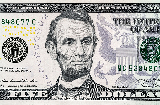 Close-up portrait of Abraham Lincoln on a 5 US dollars banknote.