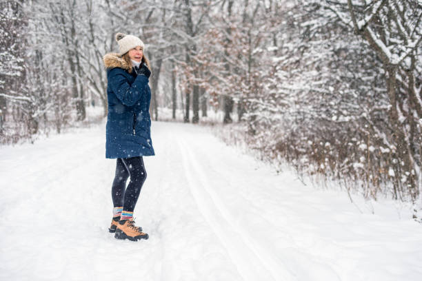 retrato de la mujer de mediana edad activa senderismo en el bosque de invierno nevado - snow hiking fotografías e imágenes de stock