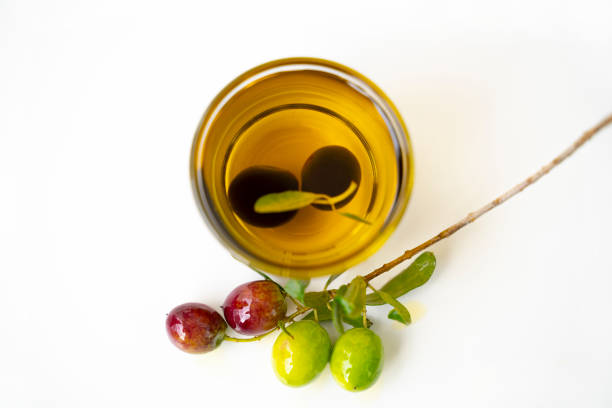 traditional manufacturing of cold-pressed olive oil, harvest of black olives in the mediterranean garden, close-up of golden oil and raw olives by the pool