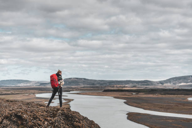 Female taking a short rest high up on the edge of a cliff  in Þjórsárdalsvegur in the southern region of Iceland.