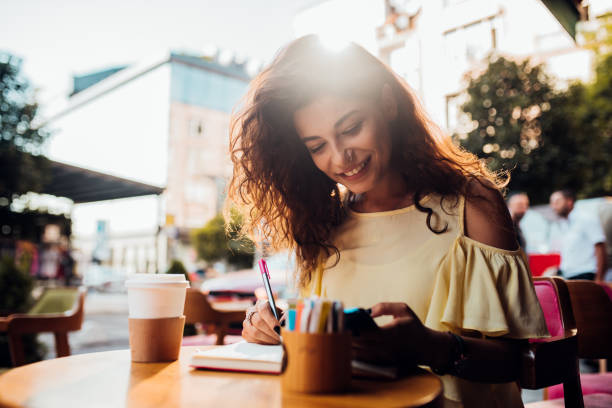 istock Beautiful girl using smartphone and writing at the cafe 1188259110