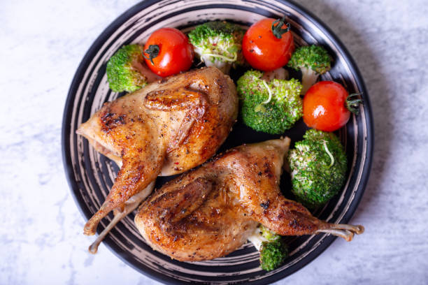 istock Quail, roasted whole, with broccoli and cherry tomatoes 1188260212