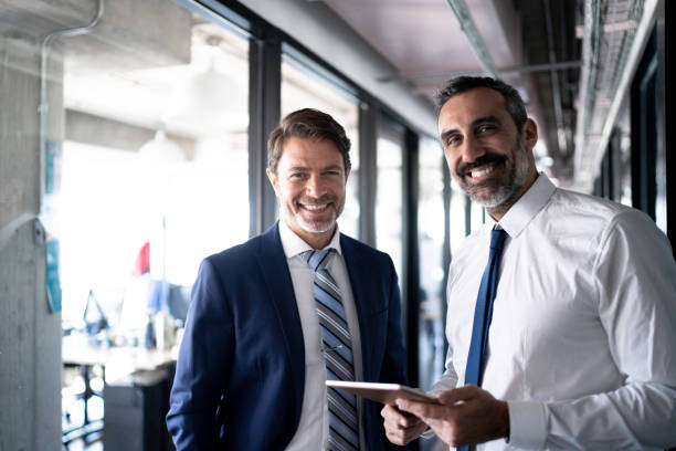 istock Portrait of coworkers using tablet at office corridor 1188262695