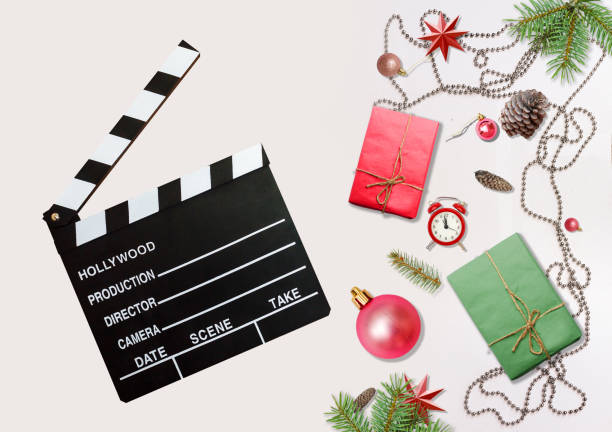 istock Two gift or present boxes, snowy fir branches, conifer cones, Christmas decoration and red berry on white table top view clapperboard 1188262827