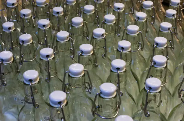 Close up of isolated group of empty glass bottles in rows with white metal swing top stopper (cliplock) - Germany