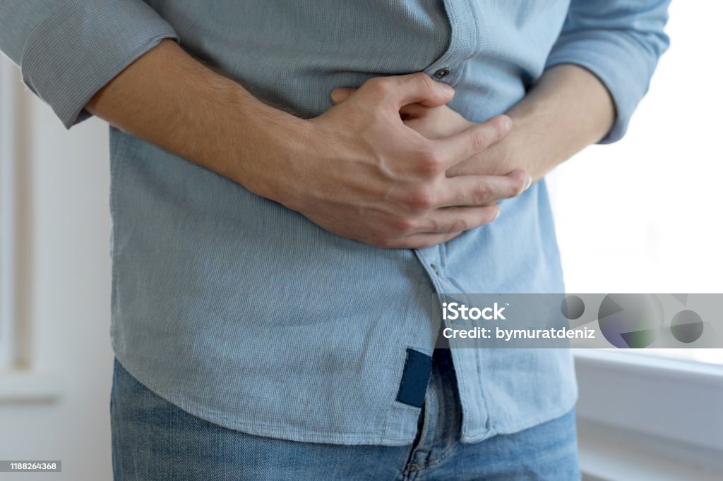Young man having stomach ache Abdomen Stock Photo