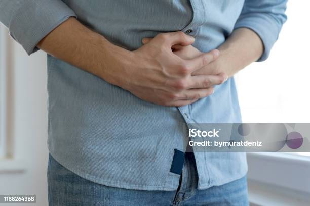 Young Man Having Stomach Ache Stock Photo - Download Image Now - Abdomen, Stomachache, Stomach